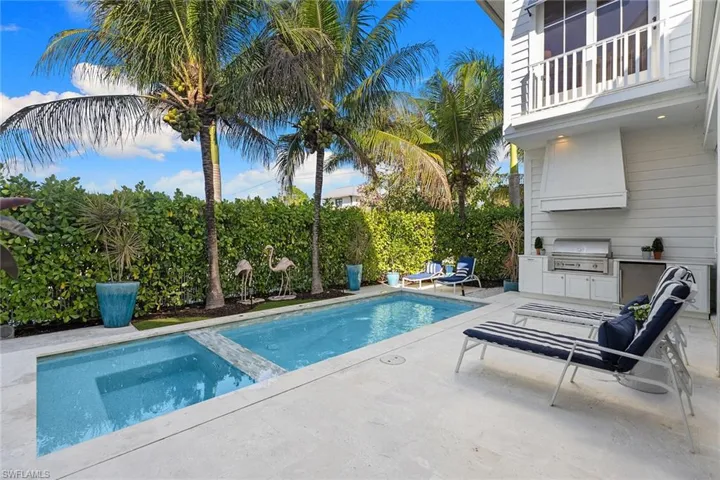 Relaxing pool / spa with a patio, exterior kitchen, and a balcony