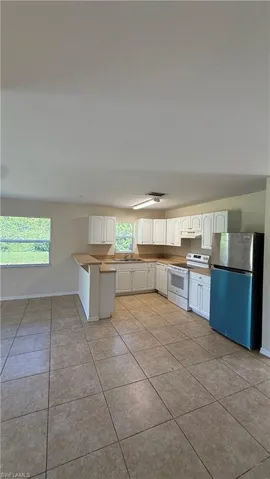 Kitchen featuring white cabinetry, light countertops, and tile flooring