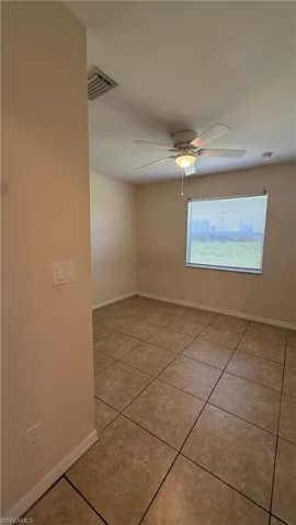 Spacious room featuring tile flooring, a window with horizontal blinds, and a ceiling fan with integrated lighting