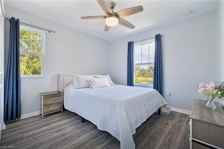 Bedroom with dark hardwood / wood-style floors and ceiling fan