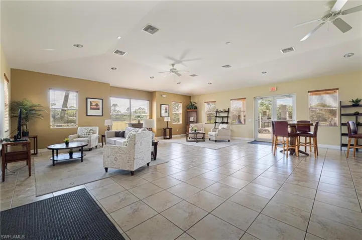 Tiled living room with lofted ceiling and ceiling fan
