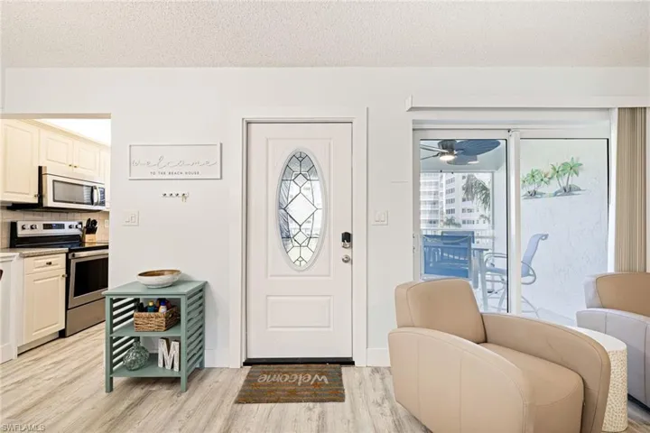 Foyer featuring light wood-style flooring, a textured ceiling, and a ceiling fan
