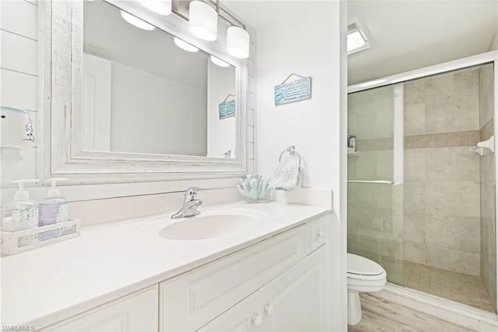 Bathroom with vanity, a shower stall, and light wood finished floors