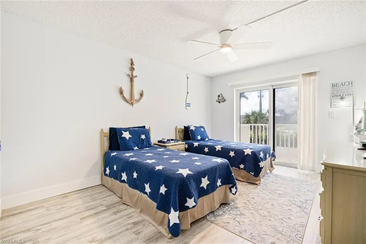 Bedroom featuring light wood-style floors, a textured ceiling, access to outside, and a ceiling fan