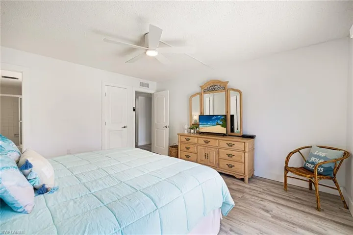 Bedroom with light wood finished floors, a textured ceiling, and a ceiling fan
