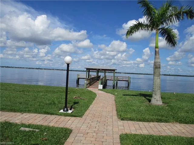 View of dock featuring a yard and a water view