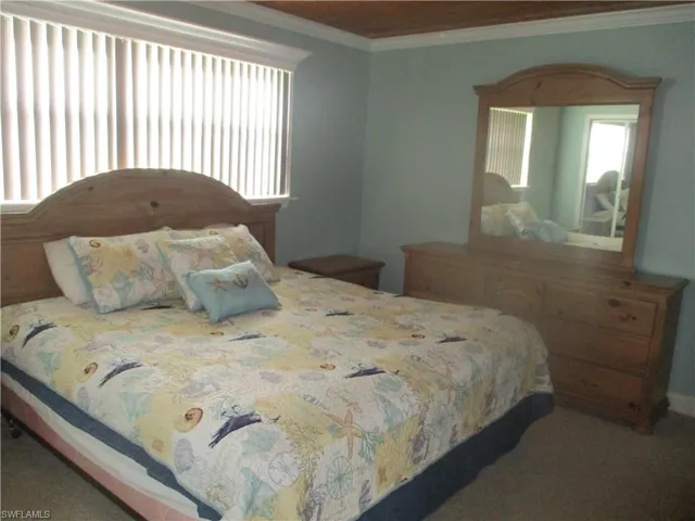 Bedroom featuring ornamental molding and carpet