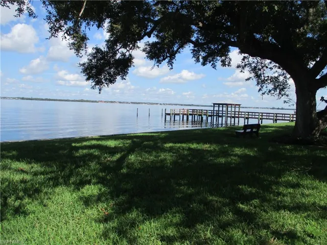 View of dock with a water view and a yard