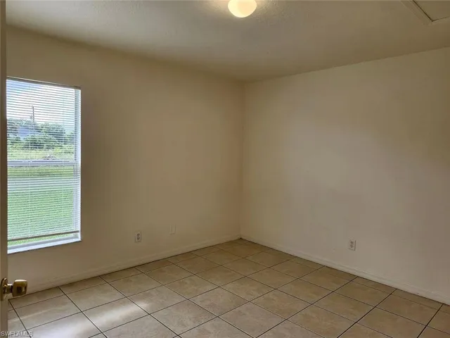 Empty room featuring light tile patterned floors and a textured ceiling
