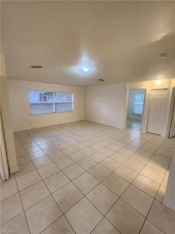 Empty room with light tile patterned floors and baseboards