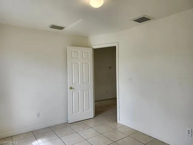 Spare room with light tile patterned floors and baseboards