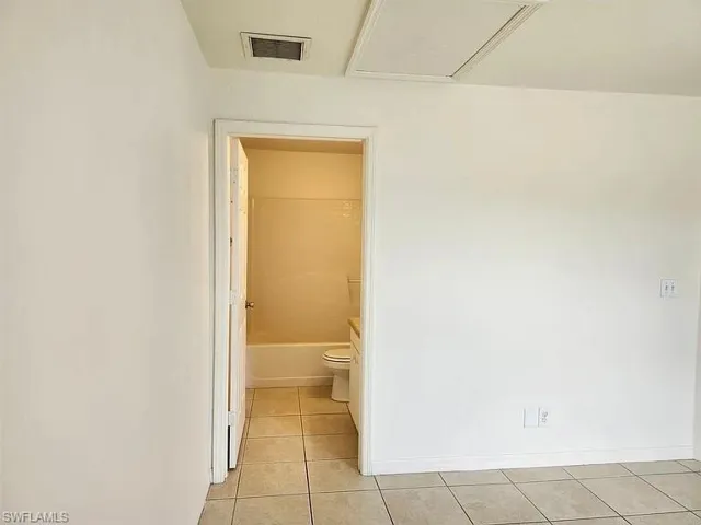 Full bathroom with light tile patterned floors and shower / bath combination