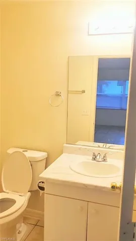 Half bath featuring light tile patterned flooring and vanity