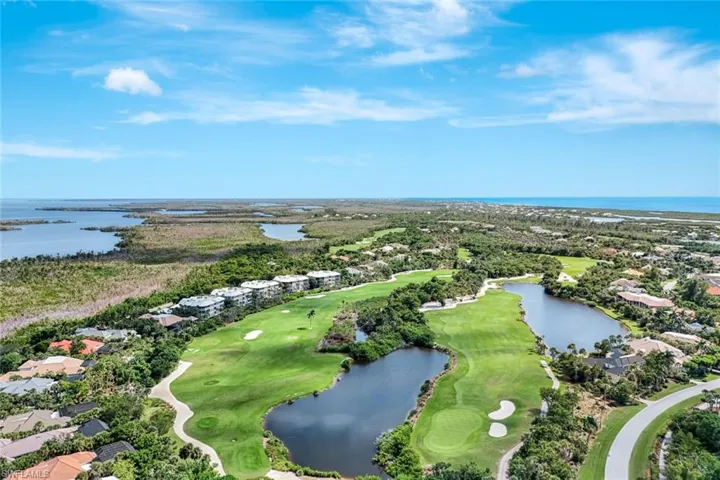 Aerial perspective of suburban area with a nearby body of water and a local golf course