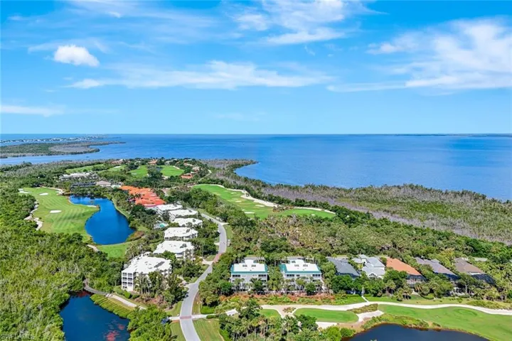 Aerial view of residential area with a golf course and a large body of water