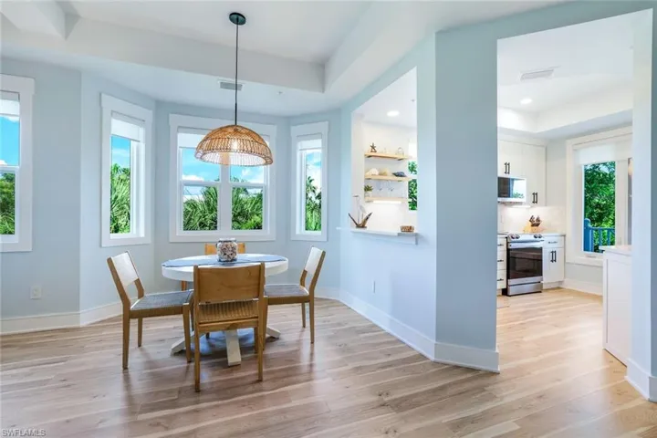 Dining area with a raised ceiling and light wood-style floors