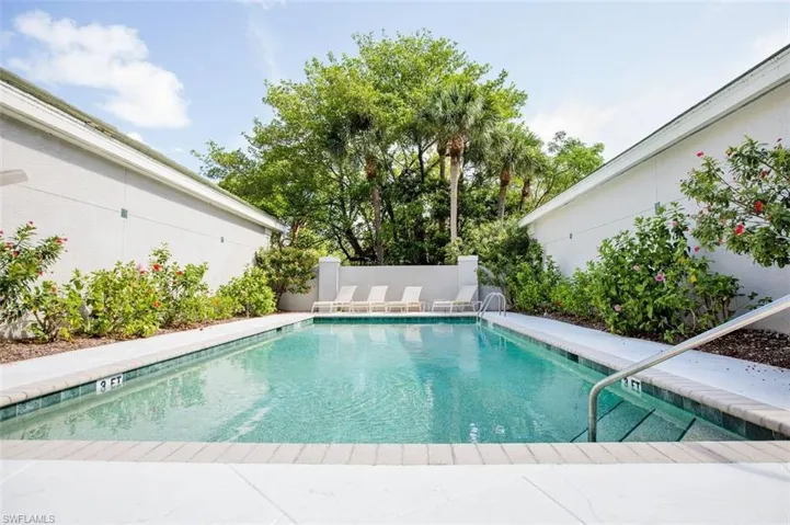 Community pool with a patio and a fenced backyard