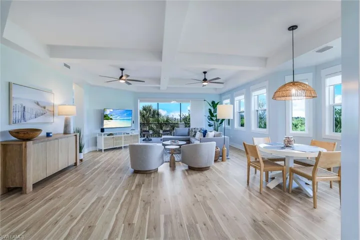 Dining area featuring beamed ceiling, coffered ceiling, light wood finished floors, and ceiling fan