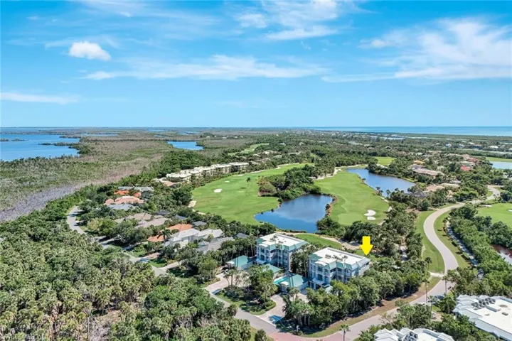 Aerial perspective of suburban area featuring a large body of water and a golf club