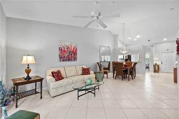 Living room featuring light tile patterned flooring, ceiling fan, recessed lighting, and high vaulted ceiling