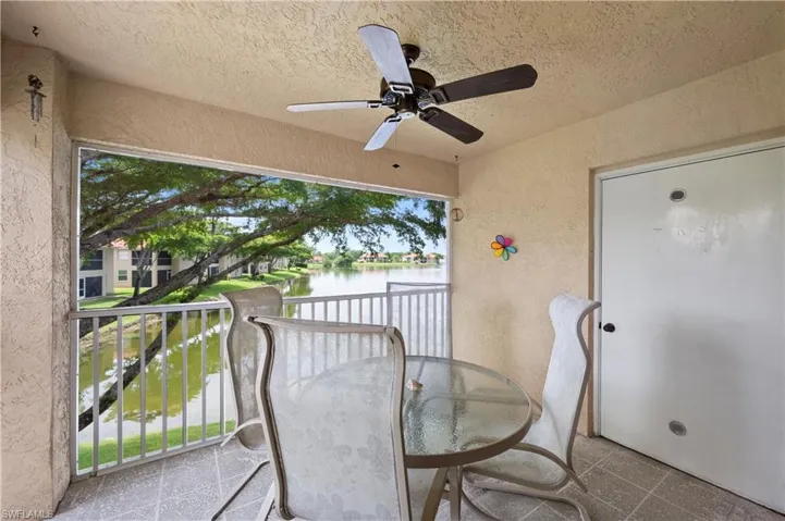 Balcony featuring a water view and a ceiling fan