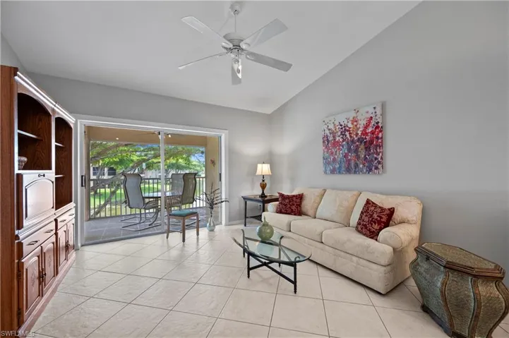 Living area featuring light tile patterned flooring, ceiling fan, and high vaulted ceiling