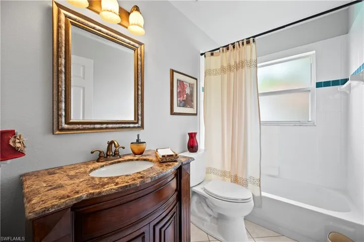 Bathroom featuring vanity, tile patterned floors, and shower / bath combo with shower curtain