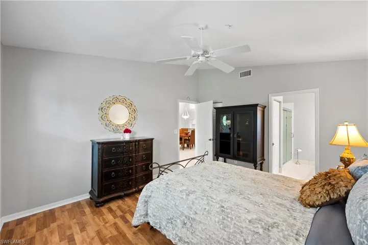 Bedroom with lofted ceiling, light wood-style flooring, and a ceiling fan