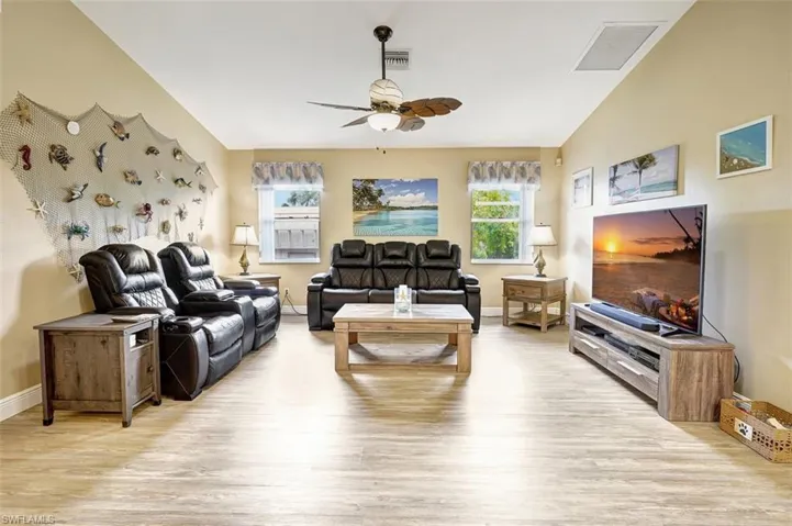 Family room featuring ceiling fan, vaulted ceiling, and wood-type flooring