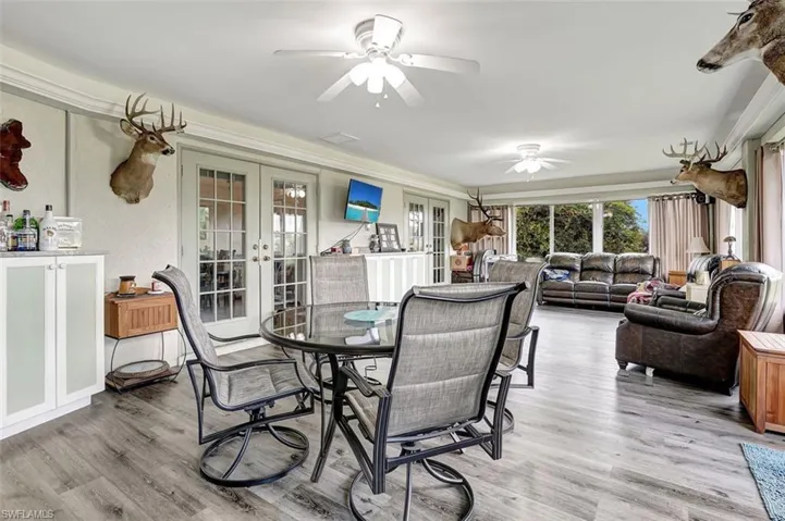 Sun room Dining area with ceiling fan, french doors, and hardwood / wood-style floors