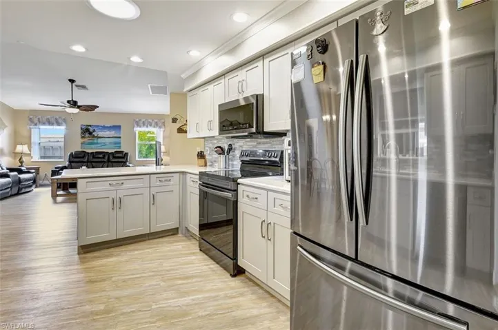 Kitchen featuring stainless steel appliances, undercounter lighting, quartz counters and backsplash
