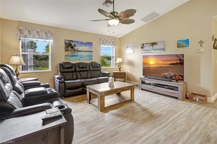 Family room with ceiling fan, vaulted ceiling, and light hardwood / wood-style flooring