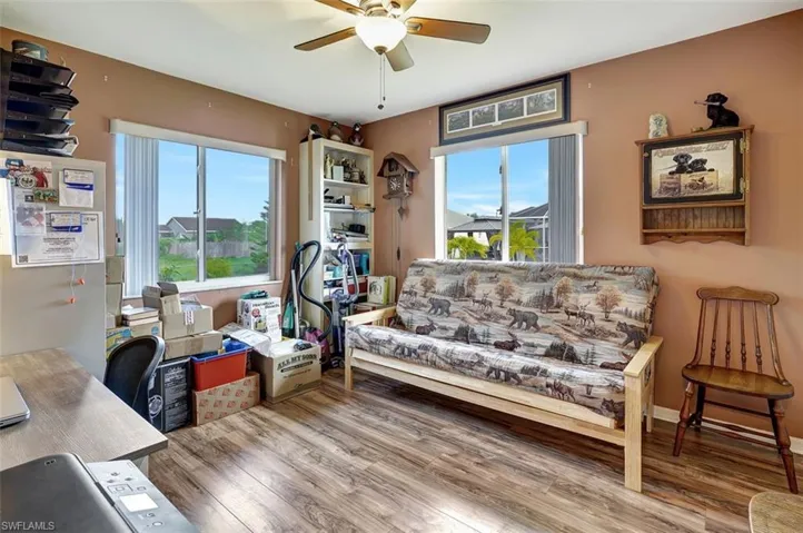 Bedroom/Office space featuring spacious walk-in closet wood-type flooring and ceiling fan