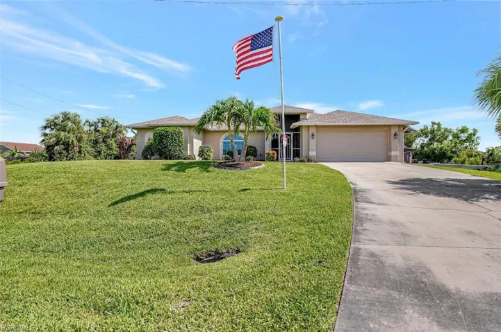 View of front of home with a garage and a front lawn