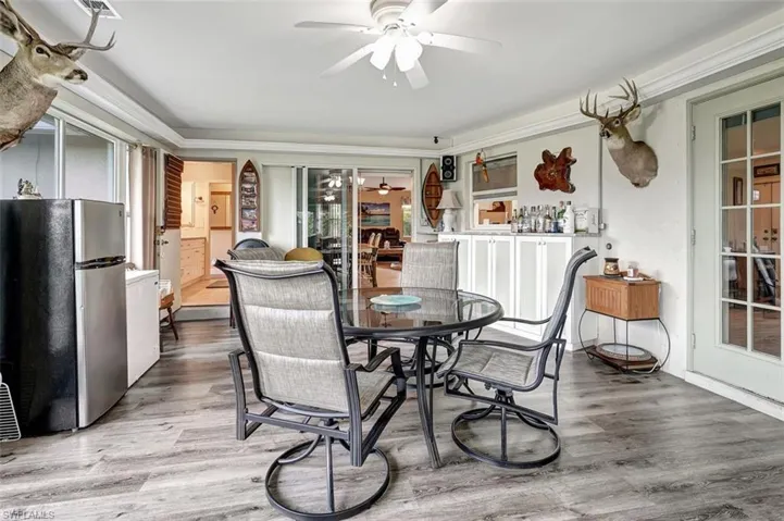 Dining space in Sun room featuring hardwood / wood-style floors, ceiling fan, and crown molding