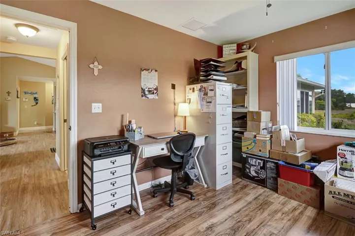 Bedroom/Office area with spacious walk-in closet and light hardwood / wood-style flooring