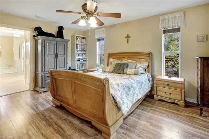 Bedroom featuring ceiling fan, hardwood / wood-style floors, and connected bathroom