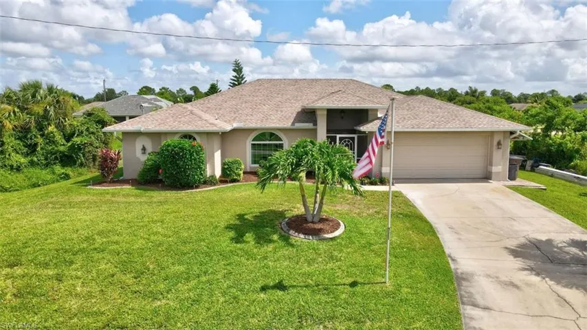 Ranch-style home with a front lawn and a garage