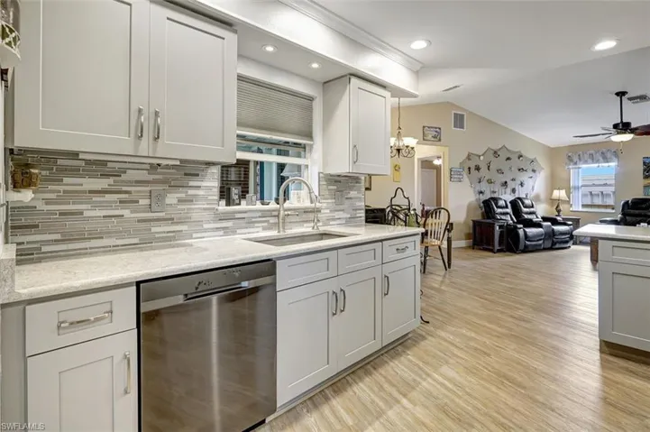 Kitchen featuring stainless steel appliances, undercounter lighting, quartz counters and backsplash