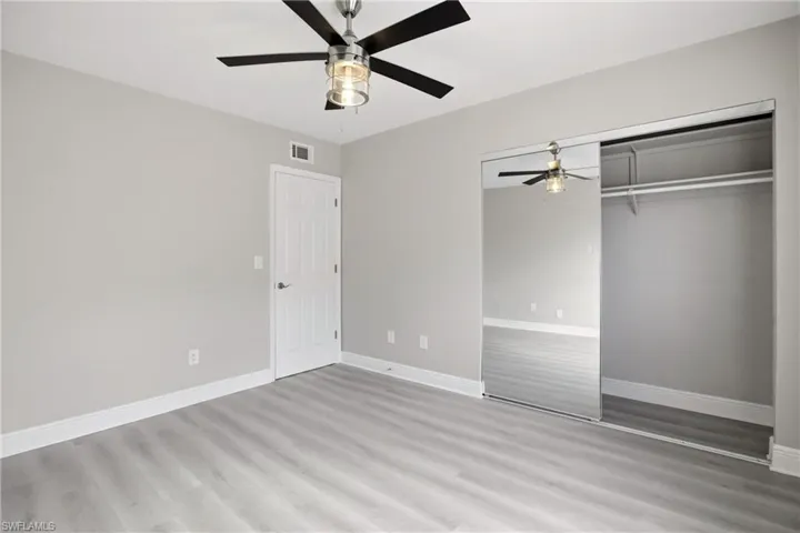 Interior room featuring wood-finish flooring, light gray walls, and white baseboards
