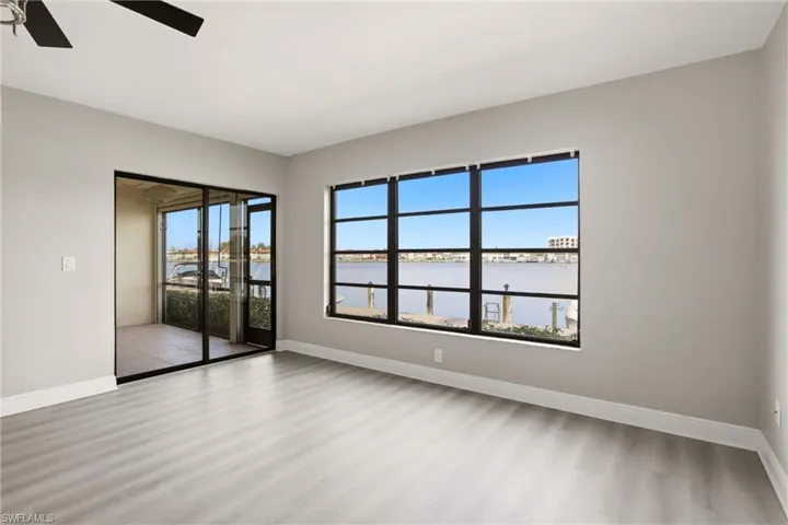 Bright interior space featuring a large window with direct water frontage