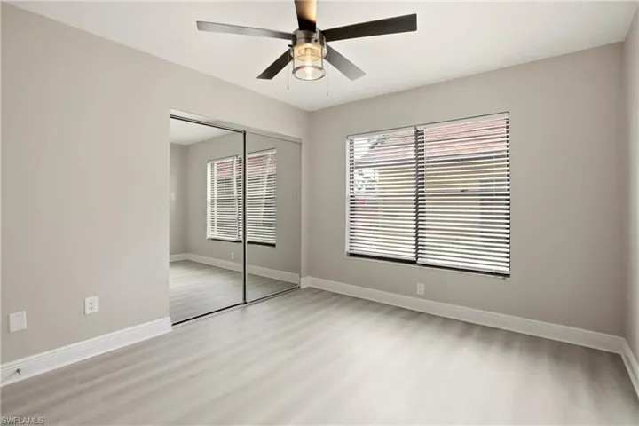 Room featuring light wood-finish flooring, a contemporary ceiling fan with integrated lighting, and a window with horizontal blinds