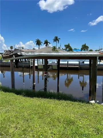 Dock area with a yard and a water view