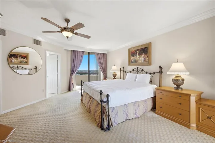 Wall-to-wall patterned carpet, crown molding, ceiling fan, and a glass sliding door providing outdoor access