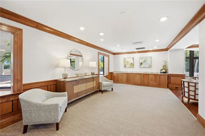 Recessed lighting, wood-finish trim, wood-paneled walls, built-in cabinetry, and neutral carpeting