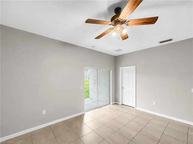 Room featuring large format tile flooring, light gray wall paint, and a wood-finish ceiling fan with integrated lighting