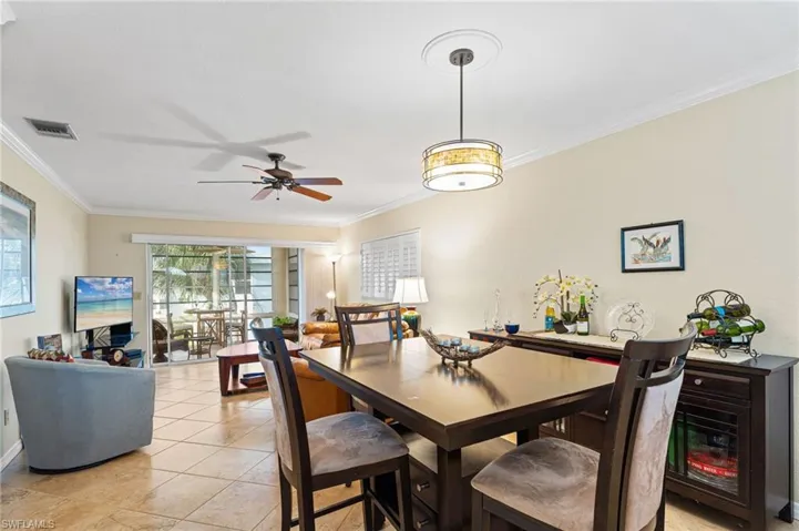 Dining area, light tile patterned flooring, and crown molding