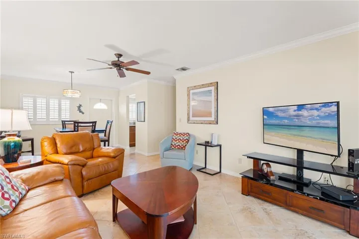 Living area with baseboards, crown molding, and light tile patterned flooring