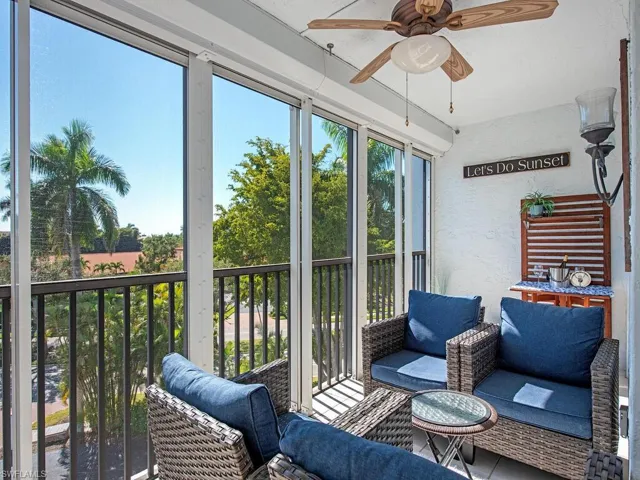 Sunroom featuring a ceiling fan and a balcony