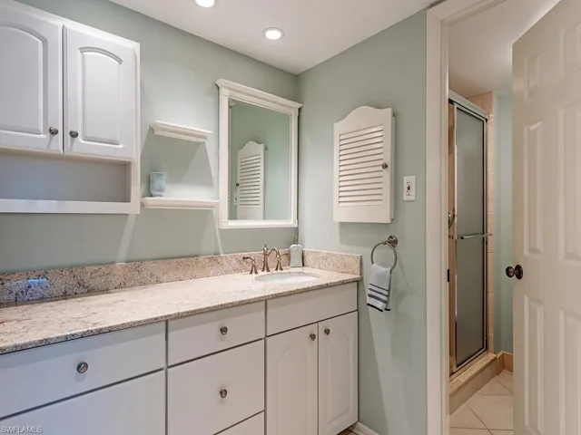 Full bath with a stall shower, light tile patterned floors, vanity, and recessed lighting